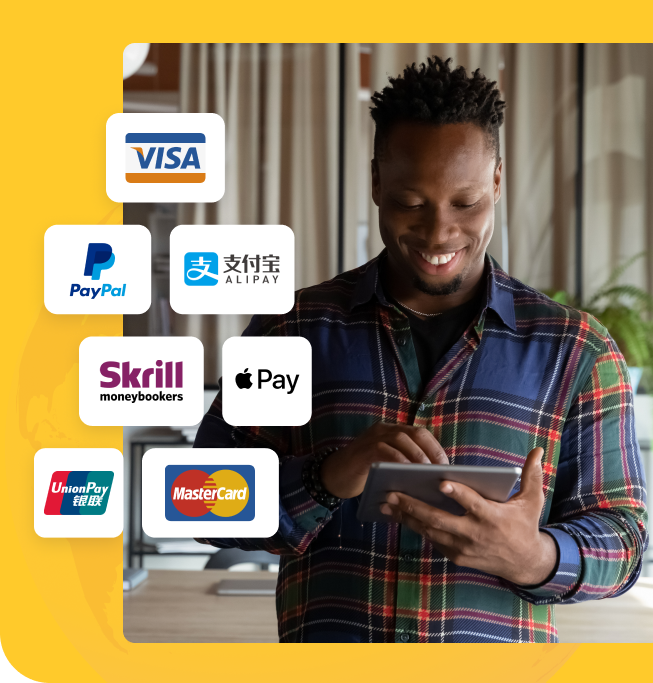 junger Mann lächelnd beim Benutzen seines Tablets mit Logos von Zahlungsmarken wie Visa, PayPal, Alipay, Apple Pay und Union Pay